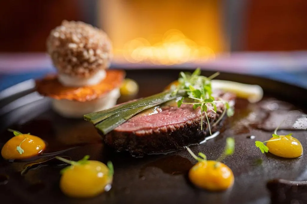 a plate of food with a piece of meat and vegetables at No11 Boutique Hotel & Brasserie in Edinburgh